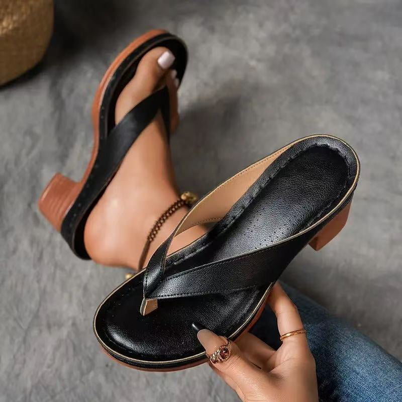 Vrouw staand met Yasmin sandalen, vanuit een lage hoek gefotografeerd, focus op de lengte van de benen en de slanke pasvorm van de sandalen.