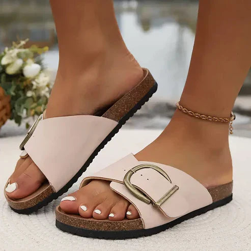 Model draagt Avelina orthopedische sandalen in beige, zittend op een stoel.