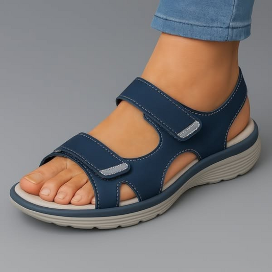 Model draagt Luvita orthopedische sandalen in het blauw, staand in een ontspannen pose.