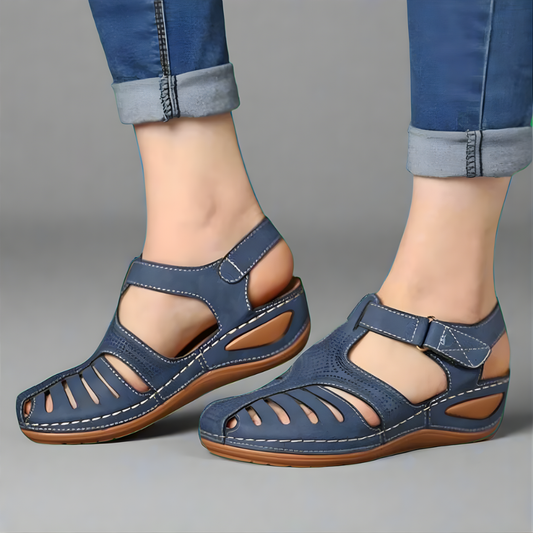 Vrouw met een blauwe Hanna Comfort Sandaal aan haar voet, die een natuurlijke uitlijning en comfort toont.