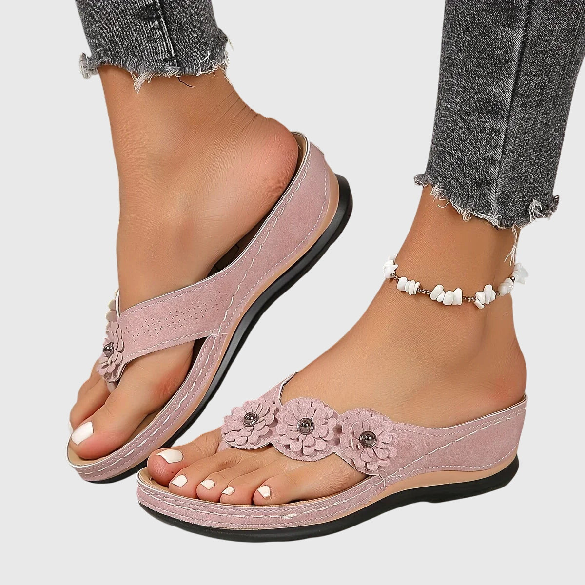 Vrouw ontspant met roze Alexis™ orthopedische teenslippers aan de voeten in een natuurlijke setting