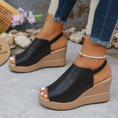 Model draagt zwarte Aurora wig sandalen, combineert elegantie met alledaags gebruik.