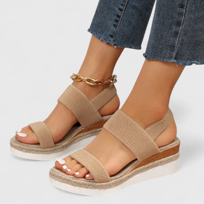 Vrouw draagt Merill Sandalen in het bruin, staand op stenen ondergrond