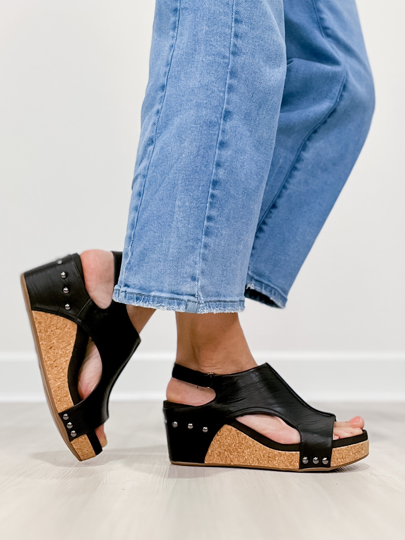 Vrouw draagt Briellae Keilsandalette in donkere kleur