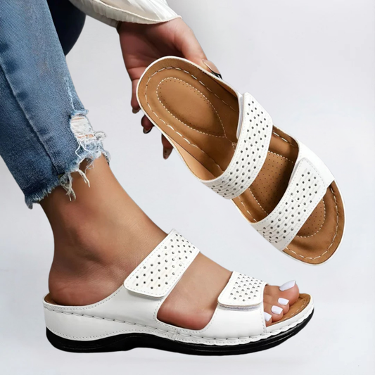 Dameshand toont de details van de witte Lynn Elegante Orthopedische Sandaal.