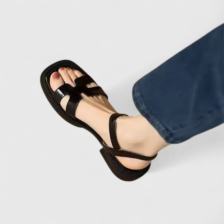 Vera elegante platte sandalen bruin aan voet van model, zijaanzicht