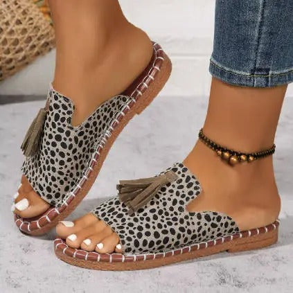 Model poseert met Lorraine™ Orthopedische Sandalen aan haar voeten, staand in een tuin.