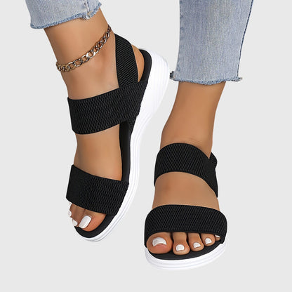 Model draagt Emila lichtgewicht stretch sandalen in zwart met elegante outfit