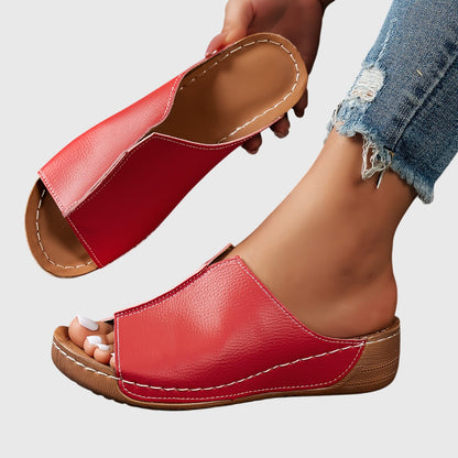 Twee Alicia™ sandalen naast elkaar, vanuit een lage hoek gefotografeerd op een natuurlijke ondergrond.