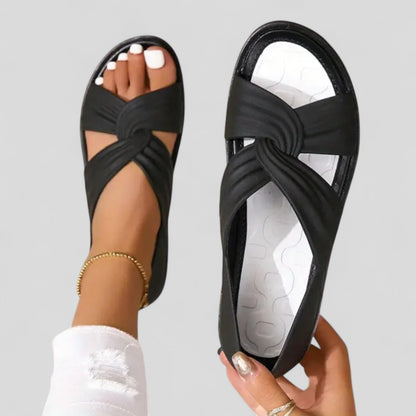 Vrouw met Lesley orthopedische sandalen in beige kleur, staand in een modern interieur.