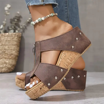 Gigi wig sandalen in bruin, zijaanzicht op een houten ondergrond